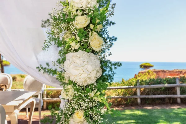 Schöner Brautstrauß aus Tüll, gebunden mit einer Schleife, auf dem Hintergrund des Ozeans. Nahaufnahme. — Stockfoto