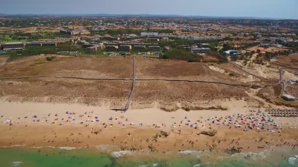 ポルトガルのガレの海岸、岩、ビーチの空中写真。観光客は、透明度の高いターコイズブルーの水で泳ぐ. — ストック動画