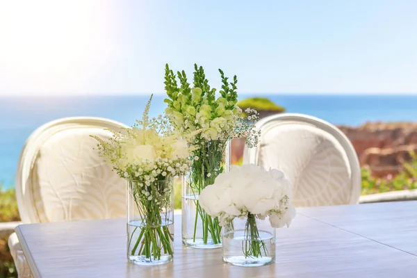 Bellissimo bouquet da sposa su un tavolo in riva al mare, sulla spiaggia in una giornata di sole . — Foto Stock