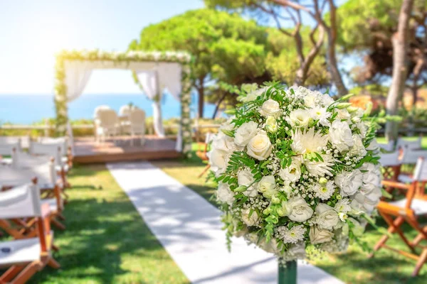 Ceremonia de boda en un hermoso césped verde junto al océano en un día soleado . — Foto de Stock