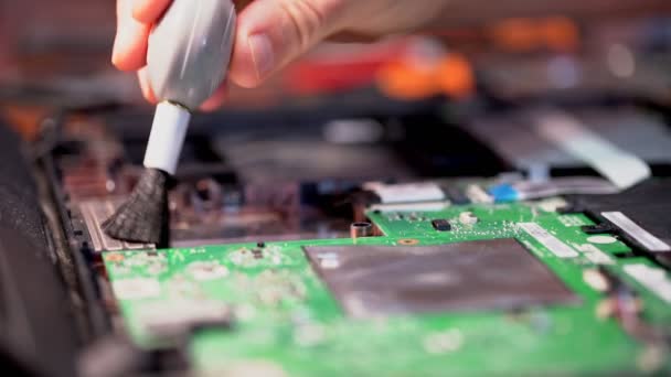 Computertechnicus reinigt de binnenkant van een laptop van stof per kwast. Close-up. — Stockvideo