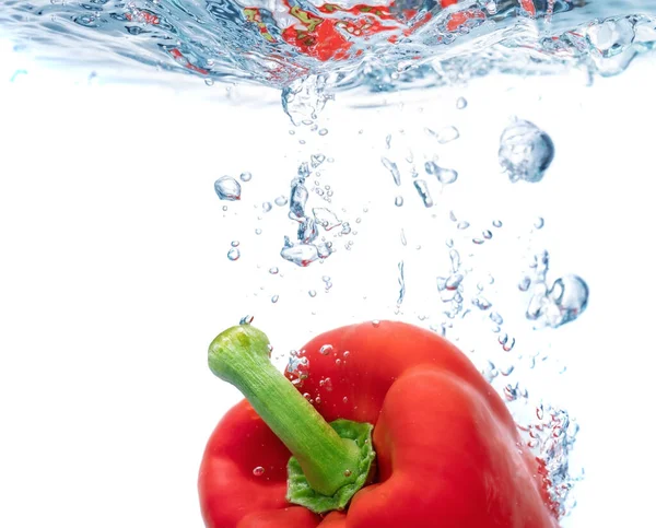 Červená paprika v čisté vodě, odrážející se od slunečního reflexu. Rozumím. Detailní záběr. — Stock fotografie