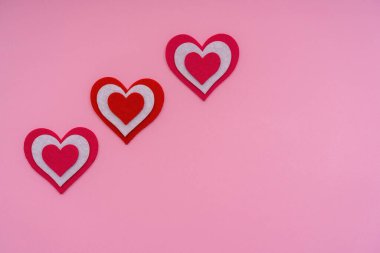 Pembe arka planda kırmızı kalpler. Kavramsal ve yaratıcı fotoğrafçılık. Boşluğu kopyala.