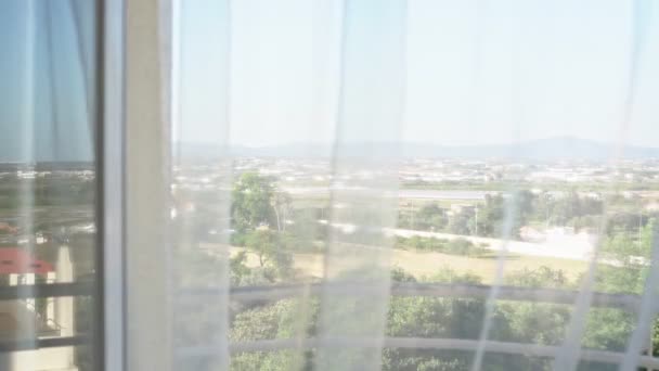 Vista de la naturaleza, paisaje a través de la ventana. El viento ligero balancea el tul. Alto perfil. Sobreexposición . — Vídeo de stock