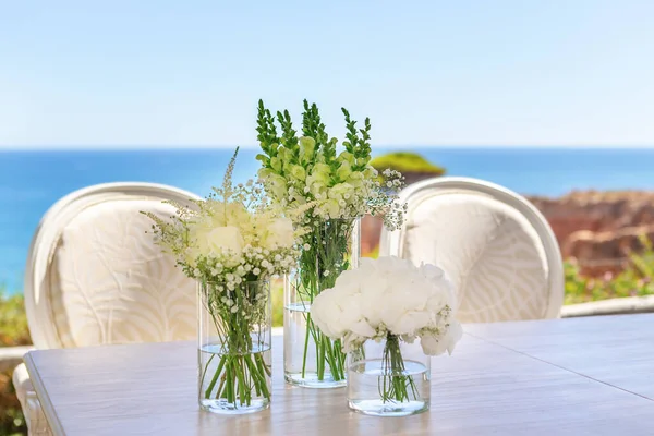 Bellissimo bouquet da sposa su un tavolo in riva al mare, sulla spiaggia . — Foto Stock