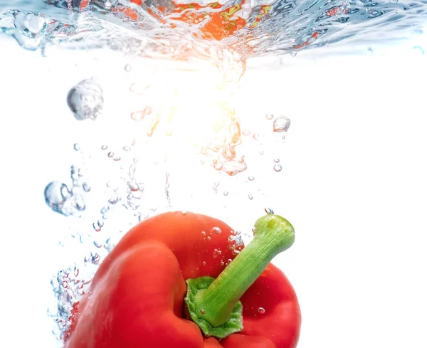 Rode paprika 's in ecologisch helder water, gereflecteerd door een zonnereflex. Close-up. — Stockfoto