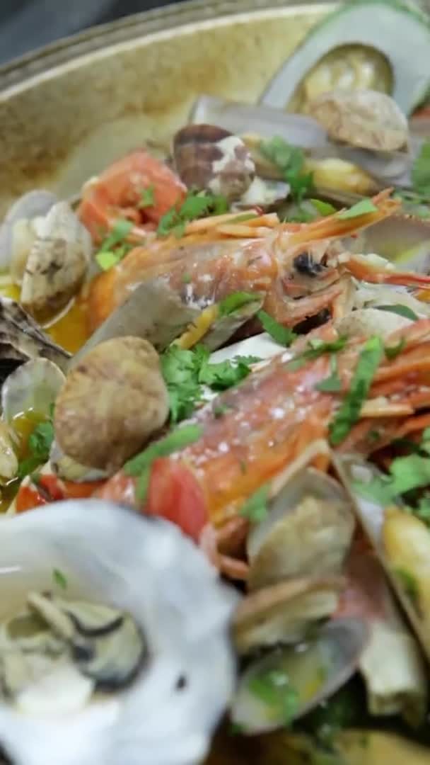 A cataplana com frutos do mar frescos e verduras cozinha-se em uma fogueira. Vídeo vertical. Close-up. — Vídeo de Stock