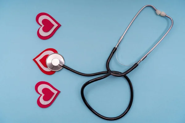 Stetoskop medicinska instrument med hjärtan på en blå bakgrund. — Stockfoto