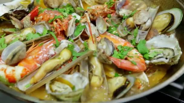 Kochen eines Kataplans, eines portugiesischen Gerichts, mit biologischen, sauberen Meeresfrüchten in Flammen. Horizontales Video. Nahaufnahme. — Stockvideo