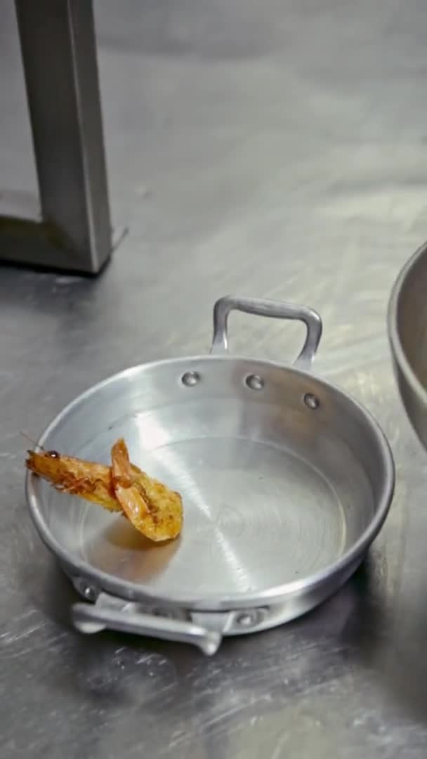 Le chef met des crevettes, des calmars dans une assiette en métal. Vidéo verticale. Gros plan. — Video