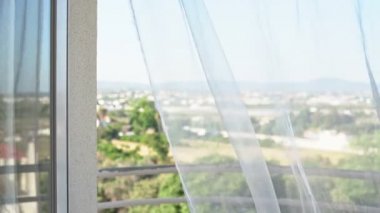 Pencereden doğa manzarası. Hafif rüzgar tülleri sallıyor. Yüksek anahtar. Aşırı pozlama.