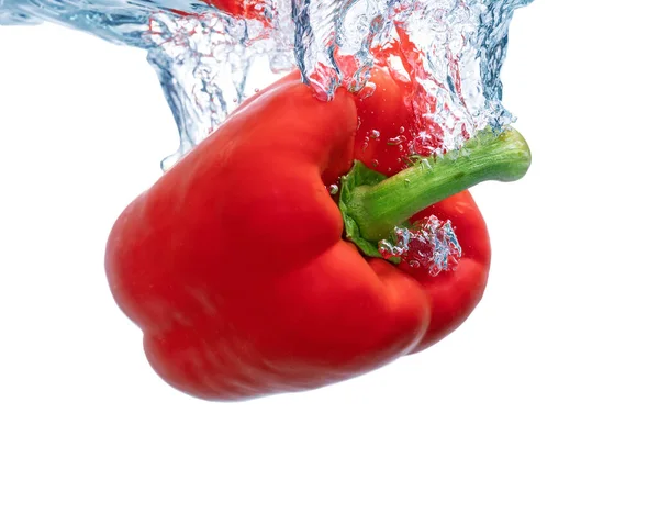 Saftige rote Paprika auf der Oberfläche des ökologischen sauberen Wassers, fallen, bilden Zwiebeln. Nahaufnahme. — Stockfoto