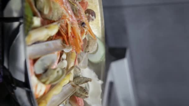 Cataplana con mariscos frescos y verduras se cocina en una chimenea. Vídeo vertical. Primer plano. — Vídeos de Stock