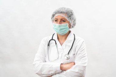 Yorgun kadın doktor, koruyucu ekipman hemşiresi ve beyaz bir arka planda virüs maskesi. Steteskopla..