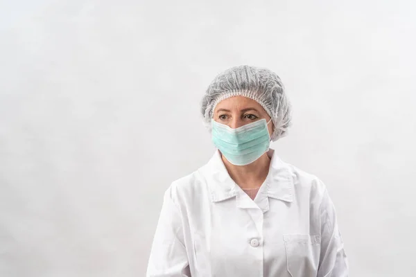 Médico mujer cansada, enfermera en equipo de protección y una máscara de virus, sobre un fondo blanco . — Foto de Stock