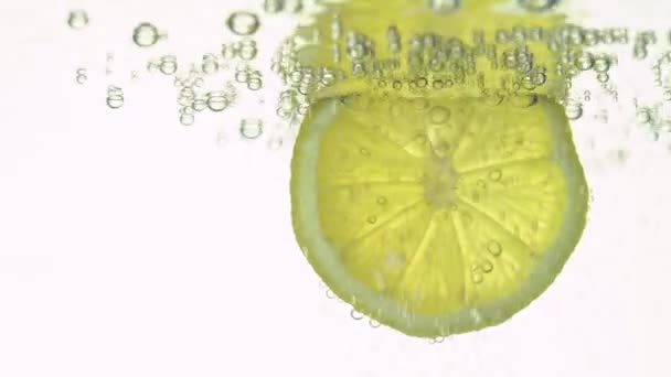 Koncept svěžesti, plátek citronu v čisté vodě, s osvěžující plynové bubliny, zblízka. Citrusové nápoje. — Stock video