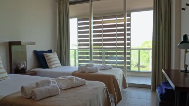Современная спальня отеля, дома с махровыми полотенцами на кровати, с видом на внутренний двор . — стоковое видео