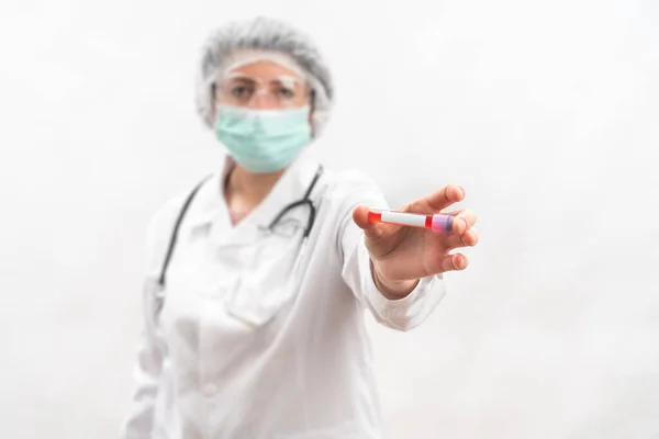 Medic nurse on a white background, shows compares, test tube with virus bacteria. — Stock Photo, Image