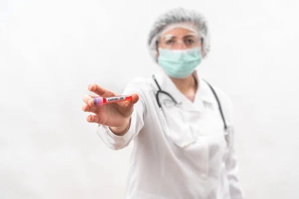 Enfermeira médica em um fundo branco, mostra compara, tubo de teste com bactérias do vírus . — Fotografia de Stock