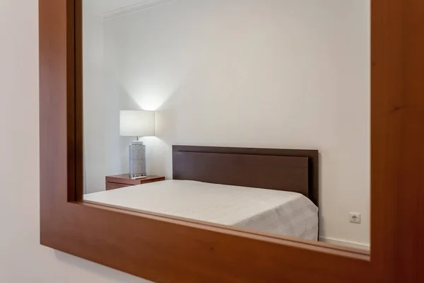 Moderne stijlvolle slaapkamer in het huis, hotel, weerspiegeld in de spiegel. Conceptuele foto. — Stockfoto