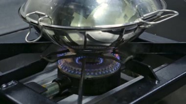 Deniz ürünleri pişirmek için gaz sobasının üzerine kataplan bakır tava. Yatay video. Yakın plan..