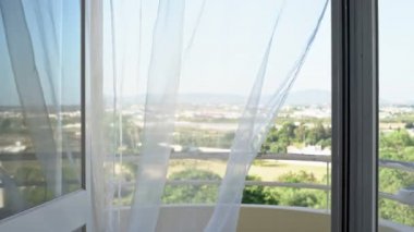 Pencereden doğa manzarası. Rüzgardan hafif bir tül salınımı. Yüksek anahtar. Aşırı pozlama.