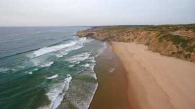 Havadan video çekimi. Sörf yapmak, Atlantik kıyısında Monte Clerigo avlamak için güzel bir kumsal manzarası. Portekiz, Sagres, Algarve, Aljezur.