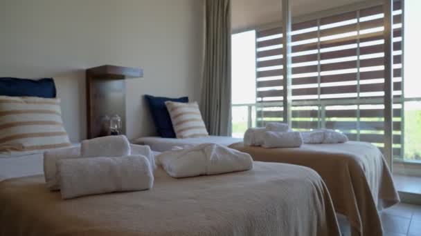 Современная спальня отеля, дома с махровыми полотенцами на кровати, с видом на внутренний двор. Медленное движение . — стоковое видео