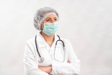 Yorgun kadın doktor, koruyucu ekipman hemşiresi ve beyaz bir arka planda virüs maskesi. Steteskopla..