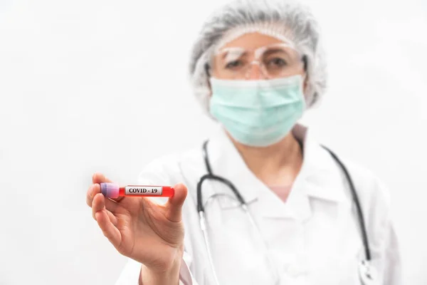 Enfermera médica en un fondo blanco, muestra comparaciones, probeta con bacterias del virus . — Foto de Stock