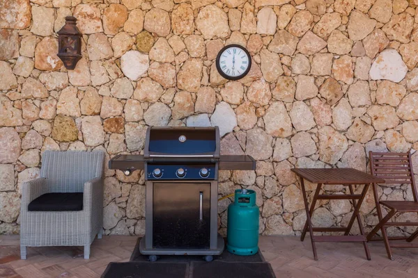 Parrilla de gas casera con cilindro, para vacaciones familiares y cenas. En el patio cerca de la pared . — Foto de Stock