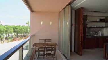 Mutfağı olan modern bir oturma odası. Parka bakan bir veranda. Yavaş çekim.