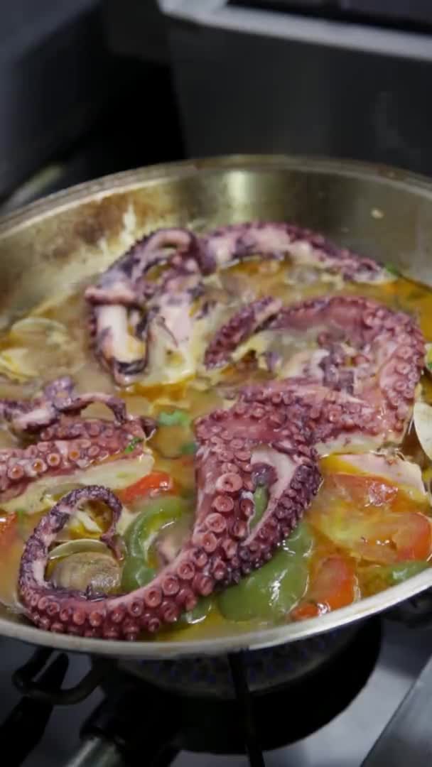 Катаплан с осьминогом, свежие морепродукты, овощи готовятся на низком огне. Вертикальное видео. Крупный план . — стоковое видео