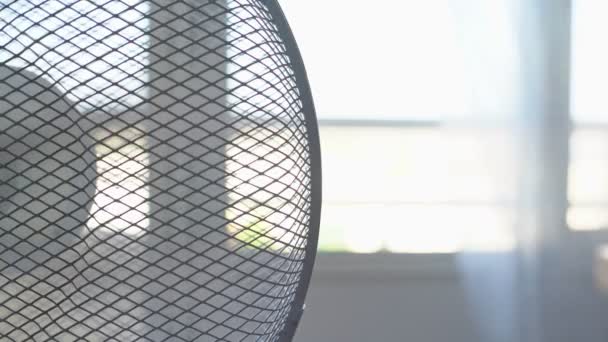 Elektrische ventilator voor het koelen van de kamer in de zomer, de warmte. Wazige achtergrond. Overbelichting. Hoge sleutel. — Stockvideo