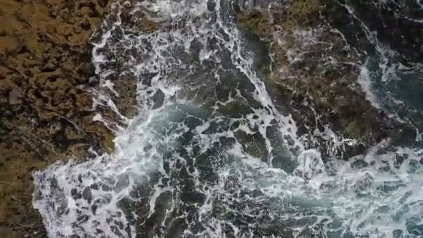 Vídeo aéreo nostálgico, em câmera lenta do mar, as ondas rolam suavemente nas margens rochosas do Oceano Atlântico Pacífico. — Vídeo de Stock