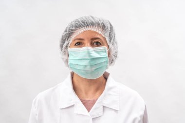 Yorgun kadın doktor, koruyucu ekipman hemşiresi ve beyaz bir arka planda virüs maskesi..