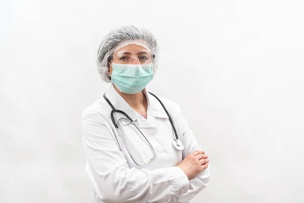 Medico femminile stanco, infermiera in attrezzature protettive e una maschera da virus, su uno sfondo bianco. Con uno stetoscopio. — Foto Stock