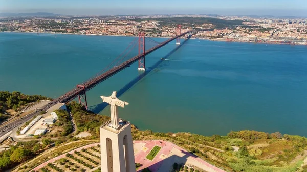 Luchtbrug op 25 april, over de Tejo rivier, standbeeld van Jezus Christus Lissabon, Portugal. Close-up. — Stockfoto