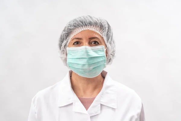 Médico mujer cansada, enfermera en equipo de protección y una máscara de virus, sobre un fondo blanco . — Foto de Stock