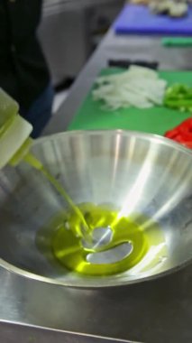 Şef taze sebzeleri kataplanın içine koyar, zeytinyağlı tarlaya. Dikey video. Yakın plan..