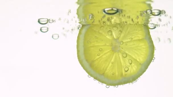 Koncept svěžesti, plátek citronu v čisté vodě, s osvěžující plynové bubliny, zblízka. Citrusové nápoje. — Stock video