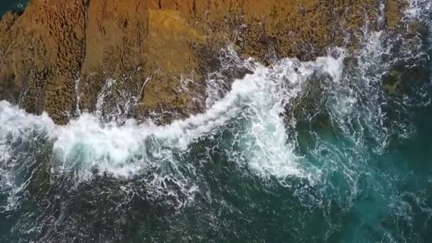 Vídeo aéreo nostálgico, em câmera lenta do mar, as ondas rolam suavemente nas margens rochosas do Oceano Atlântico Pacífico. — Vídeo de Stock