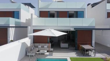 Çağdaş mimari lüks bir villanın farklı alanlarını gösteriyor. Yüzme havuzu, balkon, teras ve güneş panelleri gibi. Sürdürülebilir ve rahat bir yaşamı ön plana çıkarıyor.