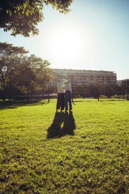 Açık hava dövüş sanatları eğitiminden sonra parlak güneş ışığının gölgesinde kalan genç adamlar..