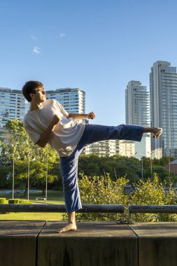 Şehir ortamında güçlü bir tekme atan genç adam.