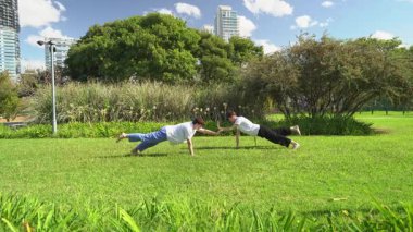 İki arkadaş parkta dövüş sanatları antrenmanı için hazırlanıyor.