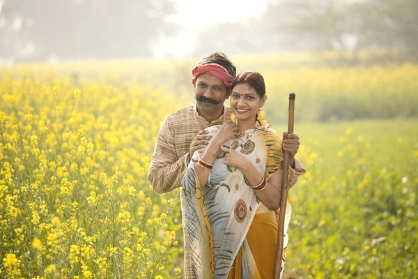站在油菜籽领域的印度农村夫妇 — 图库照片
