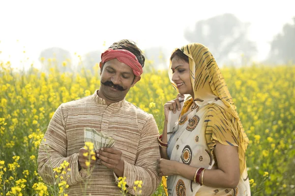 Bauernpaar hält indische Rupie-Scheine in der Landwirtschaft — Stockfoto