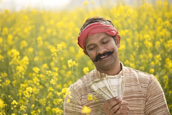 Αγρότης που κρατάει Ινδική ρουπία σημειώσεις πεδίο — Φωτογραφία Αρχείου