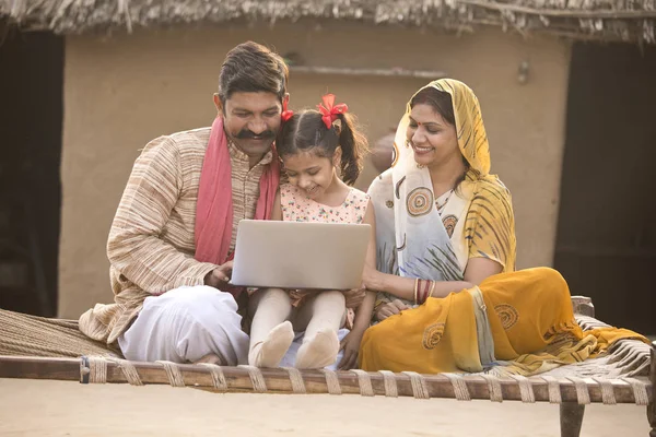 印度农村家庭在村庄的传统床上使用笔记本电脑 — 图库照片